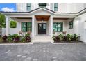 Inviting front entrance of a white home featuring double doors and a charming covered porch with seating area at 1783 Bayview Dr, Sarasota, FL 34239