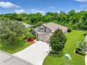 Aerial shot showcases a home with a two-car garage, manicured landscaping, and a serene, tree-lined backdrop at 5919 Lexington Dr, Parrish, FL 34219