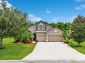 Charming home boasts a well-manicured lawn, mature trees, and a two-car garage, creating an inviting curb appeal at 5919 Lexington Dr, Parrish, FL 34219