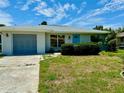 Updated ranch house with a gray garage door and nicely manicured landscaping at 3553 Syracuse St, Port Charlotte, FL 33952