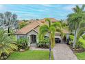 Luxury home exterior with tile roof, palm trees, and paver driveway at 4713 Mainsail Dr, Bradenton, FL 34208