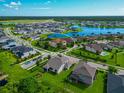 Expansive aerial view of a landscaped home in a serene, gated community near a lake and lush greenery at 2352 Marton Oak Blvd, North Port, FL 34289