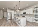 Bright and modern kitchen with a large island, stainless steel appliances, white cabinets, and decorative backsplash at 2352 Marton Oak Blvd, North Port, FL 34289