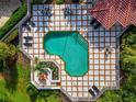 Aerial view of a private pool featuring stylish tiling, chaise lounges, and a covered dining area at 7418 Monte Verde, Sarasota, FL 34238