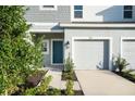 Townhome entrance with teal door, two-car garage, and walkway at 3153 Novara Ln, Lakewood Ranch, FL 34211