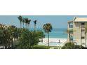 Stunning beach view with tall palms and a community pool at 500 Buttonwood Dr, Longboat Key, FL 34228