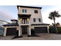 Stunning three-story home with a modern design, a welcoming front porch, and a three-car garage at 500 Buttonwood Dr, Longboat Key, FL 34228