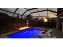 Screened-in pool with a built-in fire pit and lounge chairs for relaxing evenings at 500 Buttonwood Dr, Longboat Key, FL 34228