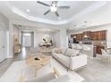 Open-concept living area flows into kitchen, featuring neutral decor, tiled floors, and comfortable seating at 11406 Belvedere Ter, Lakewood Ranch, FL 34211