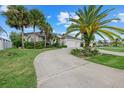 Beautiful house with well-maintained landscaping, mature palm trees, and a spacious driveway at 974 Rotonda Cir, Rotonda West, FL 33947