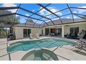 Screened-in pool and hot tub area with plenty of space for outdoor dining and relaxation at 974 Rotonda Cir, Rotonda West, FL 33947