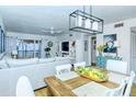 Open concept living and dining area with a farmhouse dining table and white chairs at 1801 Gulf N Dr # 275, Bradenton Beach, FL 34217