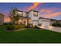 Two-story house with a three-car garage and landscaped yard at 404 158Th E St, Bradenton, FL 34212
