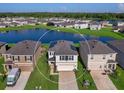 Aerial view of a two-story house with solar panels, a two-car garage and a landscaped yard at 2966 Great Abaco Way, Bradenton, FL 34208