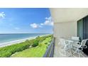 Balcony with table and chairs overlooking the beach and ocean at 1045 Gulf Of Mexico Dr # 403, Longboat Key, FL 34228