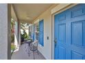 Inviting front porch featuring blue door, table and chairs, perfect for relaxing and enjoying the outdoors at 11622 Summit Rock Ct, Parrish, FL 34219