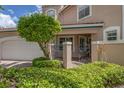 Partial view of a tan townhome showcasing a gated entry and lush landscaping at 1711 Starling Dr # 1711, Sarasota, FL 34231