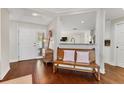 Bright entryway with hardwood floors, bench, and view into the kitchen at 1711 Starling Dr # 1711, Sarasota, FL 34231