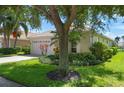 Single story home with a large oak tree and attached garage at 4140 Reflections Pkwy, Sarasota, FL 34233