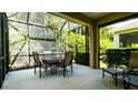 Comfortable screened patio with an outdoor dining table, chairs, and a lush green view at 4830 Maymont Park Cir, Bradenton, FL 34203