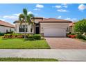 One-story house with landscaped yard and brick driveway at 25081 Spartina Dr, Venice, FL 34293