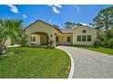 Front view of charming Spanish style home with a covered entryway at 360 N Point Rd, Osprey, FL 34229