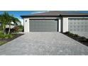 Gray paver driveway leading to a two-car garage at 2088 Bonito Way, Port Charlotte, FL 33953