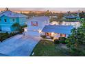 Beautiful two-story home with a well-manicured lawn, pink shutters, and an attached garage at 508 65Th St, Holmes Beach, FL 34217
