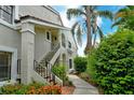 Two-story condo featuring landscaped grounds and an exterior staircase with black railings at 7673 Fairway Woods Dr # 706, Sarasota, FL 34238