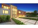 Modern home with brick and wood siding, double garage and landscaped walkway at dusk at 2945 Pyrula Dr, Longboat Key, FL 34228