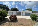 Updated single story home with gray garage door and landscaped yard at 906 Southern Pine Ln, Sarasota, FL 34243