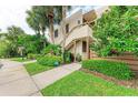 Condo building exterior showcasing a staircase and tropical landscaping at 184 Pineneedle Dr # 184, Bradenton, FL 34210