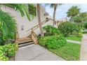 Condo building exterior featuring a wooden staircase and green landscaping at 184 Pineneedle Dr # 184, Bradenton, FL 34210