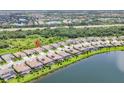 An aerial view of the property shows the tile roof and lake view, within a well-kept residential neighborhood at 17723 Polo Trl, Bradenton, FL 34211