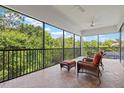 Relaxing screened patio with comfortable seating, ceiling fans, and a serene view of the surrounding lush greenery at 13215 Palmers Creek Ter, Lakewood Ranch, FL 34202