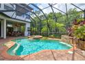 Inviting screened-in pool and spa area featuring a rock waterfall and a covered patio at 13215 Palmers Creek Ter, Lakewood Ranch, FL 34202