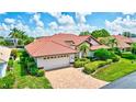 Single story home with tile roof, two car garage and manicured landscaping at 90 Inlets Blvd # 90, Nokomis, FL 34275