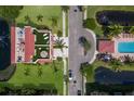 An aerial view showcases the green rooftop, pool, landscaping and road at 1450 Silvia Shores Dr, Apollo Beach, FL 33572