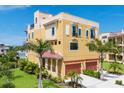 Stunning three-story home with a two-car garage and beautifully landscaped yard featuring mature palm trees at 1450 Silvia Shores Dr, Apollo Beach, FL 33572