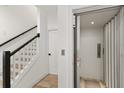 Bright hallway featuring an elevator, stairs with dark railings, and neutral decor at 1450 Silvia Shores Dr, Apollo Beach, FL 33572