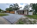 Newly renovated home with a large paved driveway and a fenced-in yard at 1610 24Th St, Sarasota, FL 34234