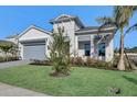 Single-story home with gray garage, landscaping and palm trees at 17931 Palmiste Dr, Bradenton, FL 34202