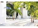 Bright and airy front porch with white adirondack chairs and white rock landscaping at 11061 Sandrift Ave, Englewood, FL 34224