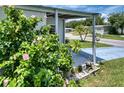 Landscaped yard with flowering plants and a paved driveway at 6428 Fleetwood Ct, North Port, FL 34287