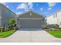 View of the two-car garage on a home with a well-kept lawn and simple landscaping at 5917 Laurelcrest Gln, Palmetto, FL 34221