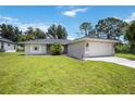 Single-story house with a star feature, attached garage, and grassy yard at 4528 Kendall Ave, North Port, FL 34286