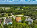 Aerial view showcases a home with a pool, surrounded by lush greenery and neighboring houses at 14526 17Th E Ave, Bradenton, FL 34212
