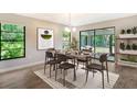 Modern staged dining room, featuring a wood table and chairs at 7301 Ballantrae Pl # 27D, Sarasota, FL 34238