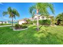 Landscaped front yard with lush grass, palm trees, and colorful flowers at 139 Long Meadow Lane Ln, Rotonda West, FL 33947