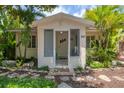 Quaint house exterior showcasing a screened-in porch and lush landscaping at 839 40Th St, Sarasota, FL 34234